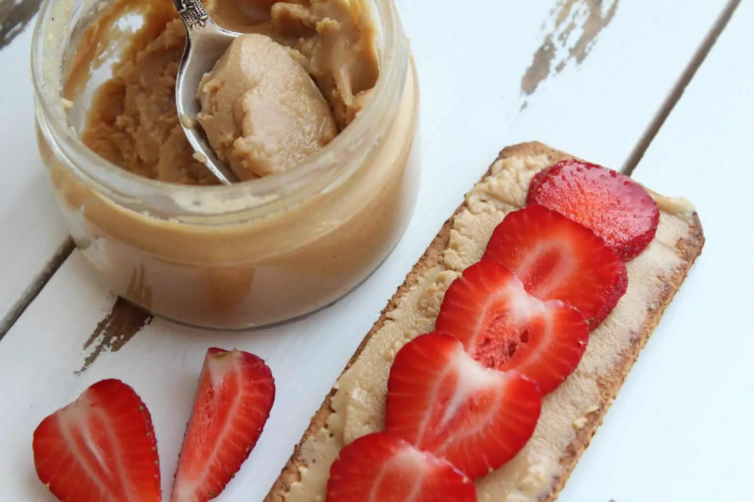 Peanut butter and slices of a strawberry
