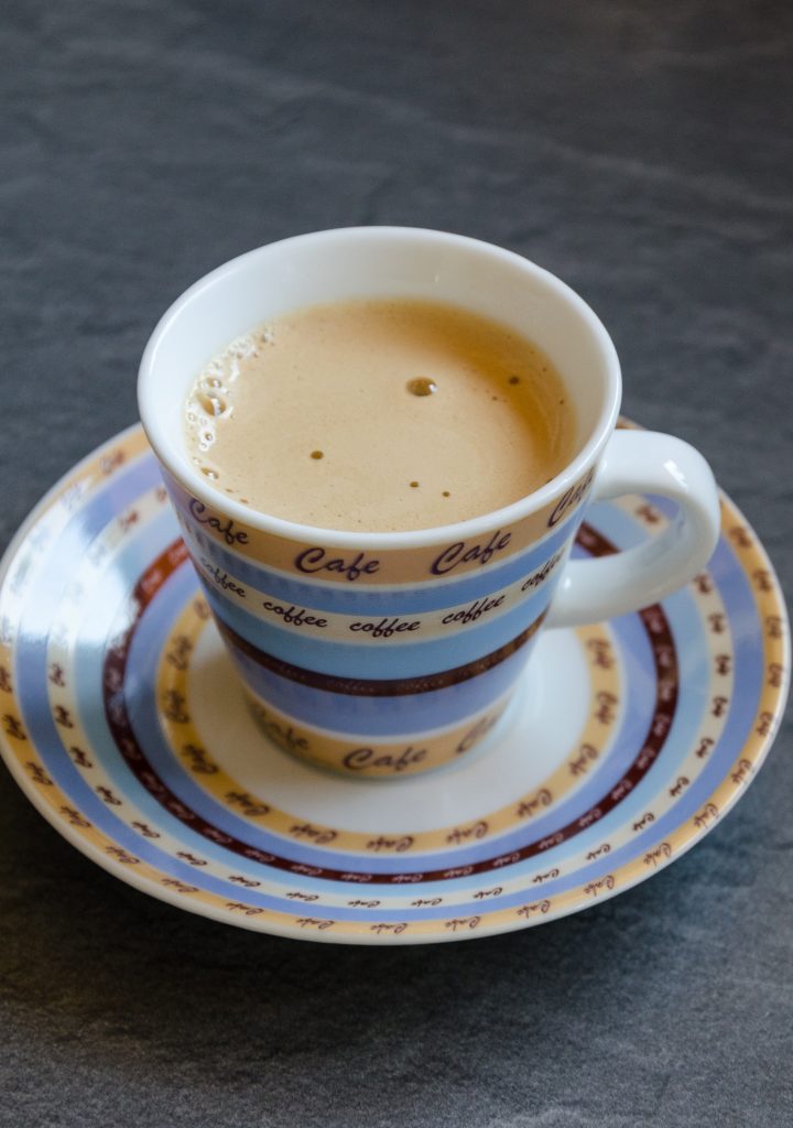 A cuban coffee served in a tea cup and plate