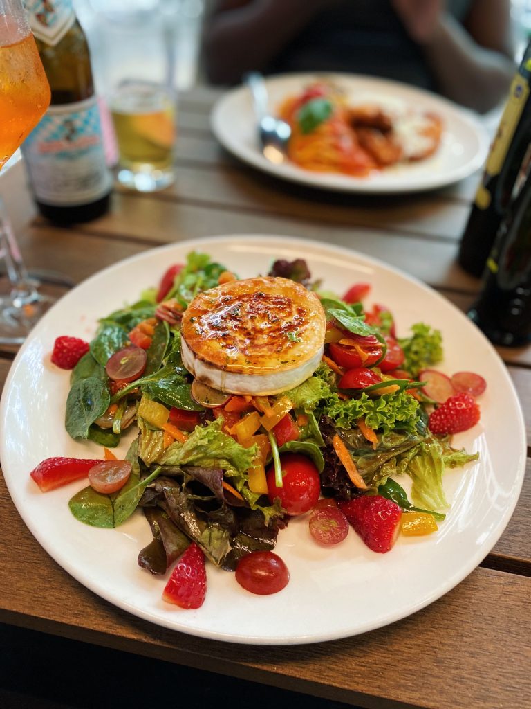 A vegetable salad meal with goat cheese on top