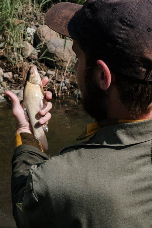 Man holding his freshly caught fish from the river