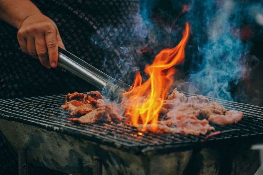 Woman grilling pork in backyard