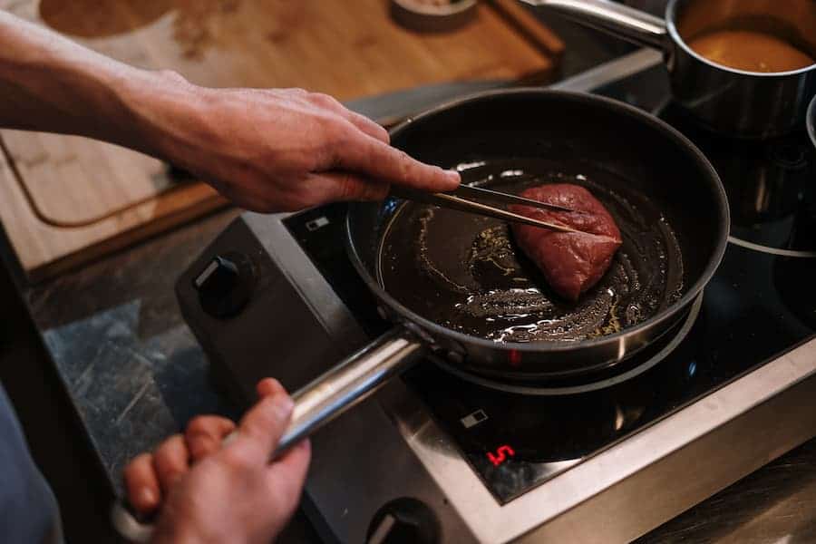 Searing a piece of pork on a pan