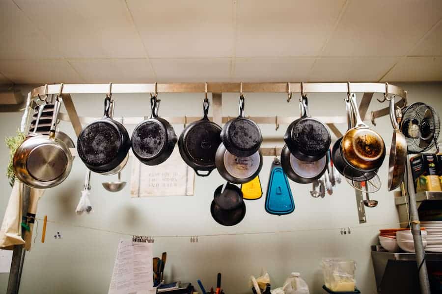 Types cookware set hanging in kitchen