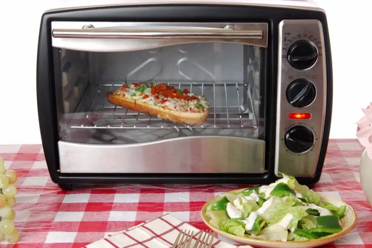 Frozen pizza being reheated in a toaster oven
