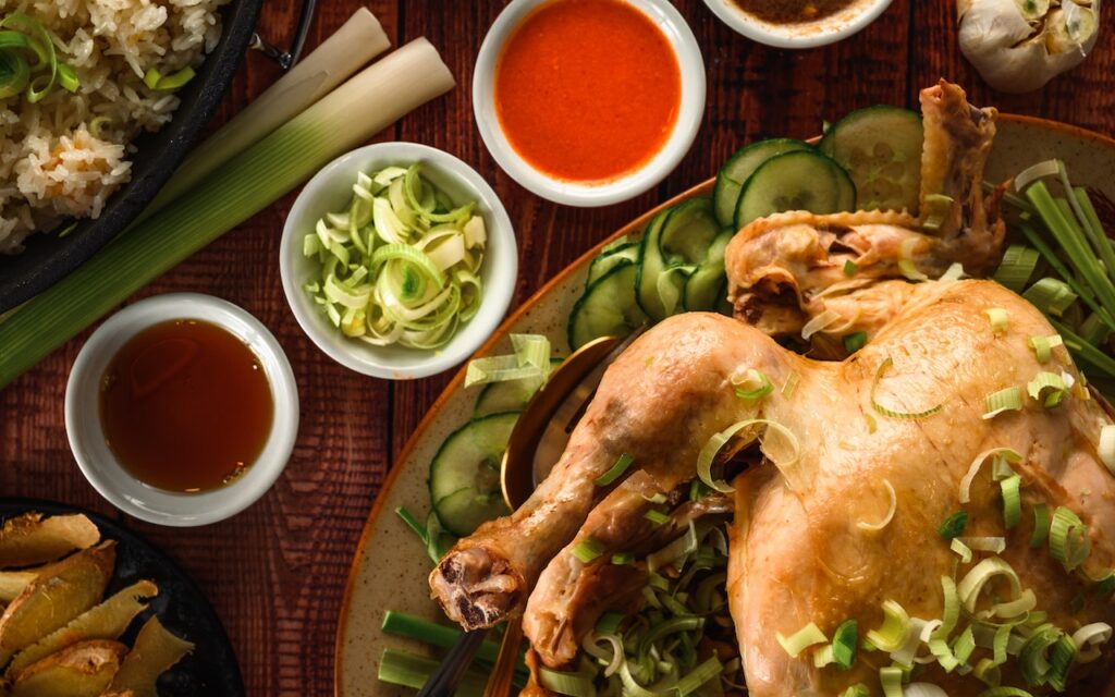 A top view of a whole chicken with herbs and spices on a brown plate