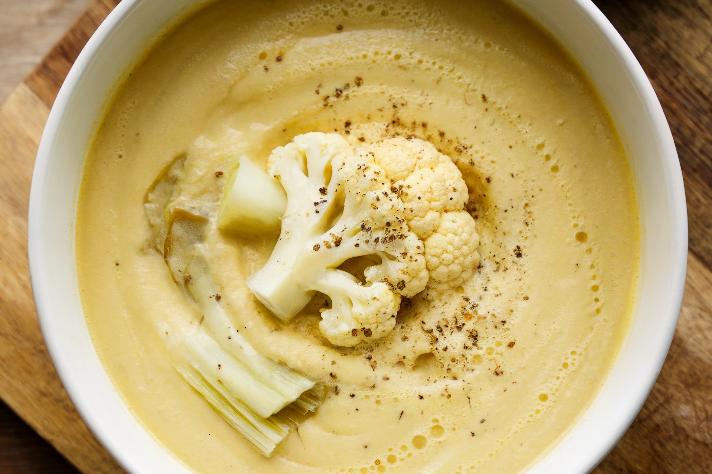 Creamy cauliflower soup garnished with roasted florets and spices