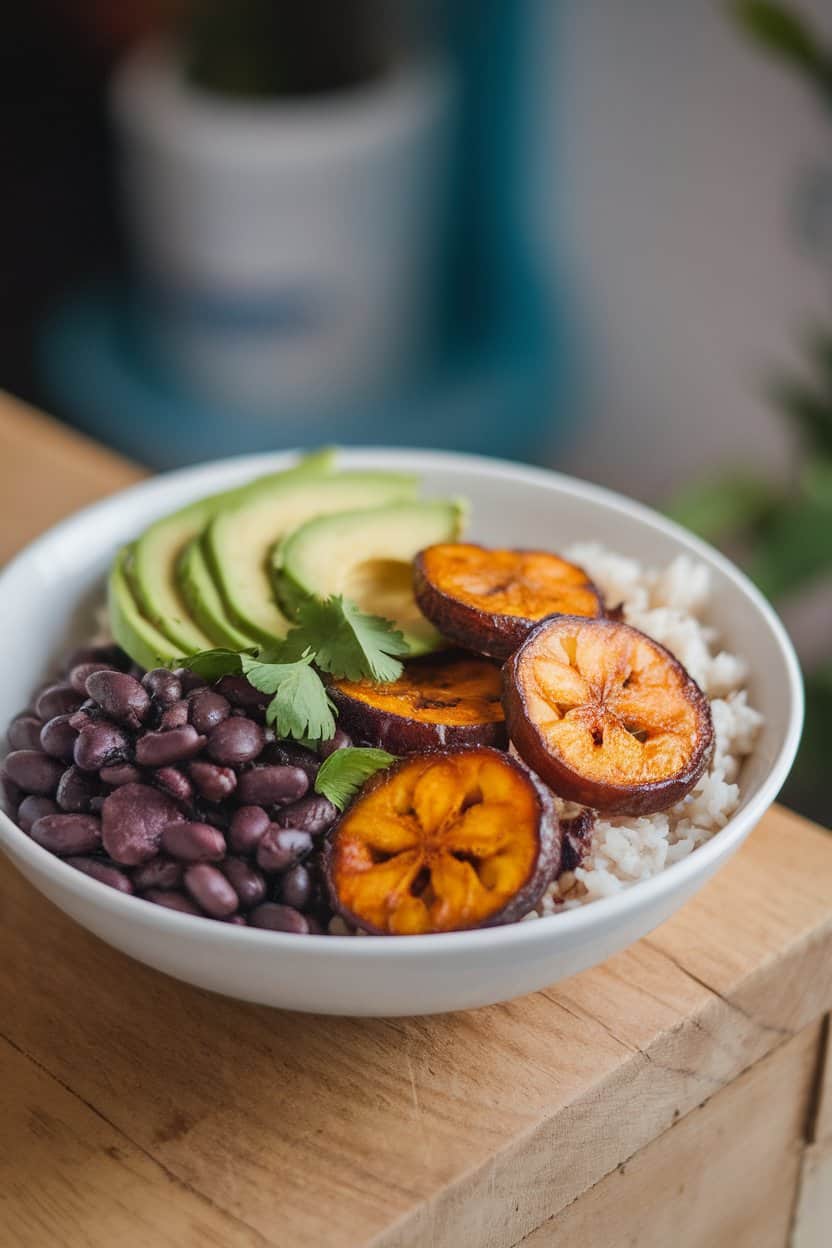 Indoor bowl with black beans, caramelized plantain slices, rice, and avocado, vibrant colors under soft light, no text or logos.